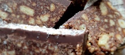 Stone wall cafe with outdoor tables behind iron fence with flowers at Caherconnell Stone Fort